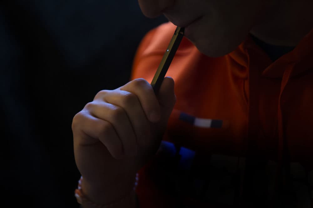 A teen uses a JUUL vaping device at home. (Jesse Costa/WBUR)