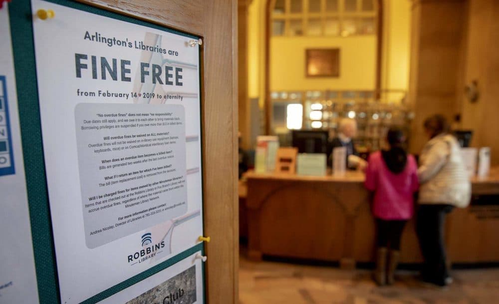 A flyer near the check-out desk explains Arlington’s fine free policy. (Robin Lubbock/WBUR)