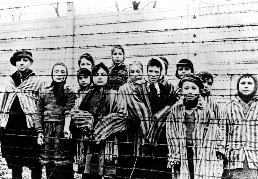 A picture taken just after the liberation by the Soviet army in January 1945, shows a group of children wearing concentration camp uniforms behind barbed wire fencing in the Auschwitz Nazi concentration camp. (AP file photo)