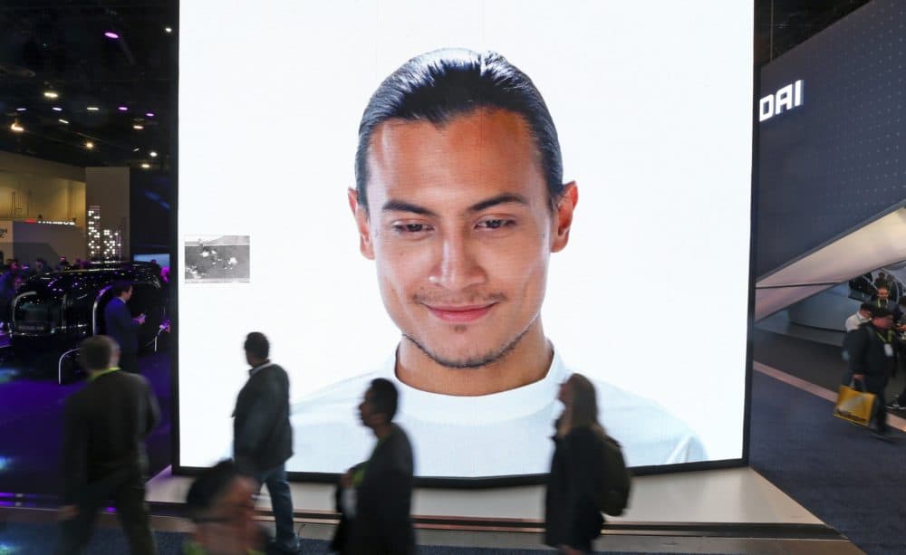 A giant KIA video screen advertises facial recognition in prototype vehicles as patrons walk past at the Consumer Electronics Show International Jan. 9, 2019, in Las Vegas. (Ross D. Franklin/AP)