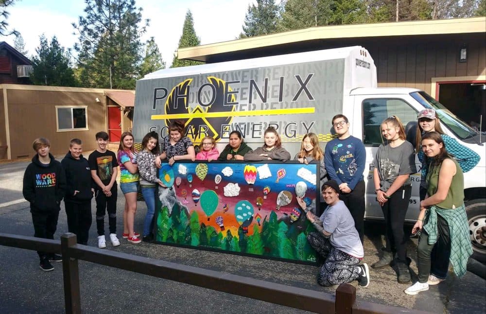 Students display their mural that will eventually hang at the school. (Ashley Bailey/Here & Now)