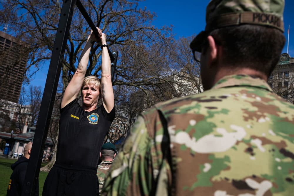 Master Sgt. Shelley Horner, fitness trainer for the Texas Army National Guard, demonstrates a leg tuck. (Erin Clark for WBUR)