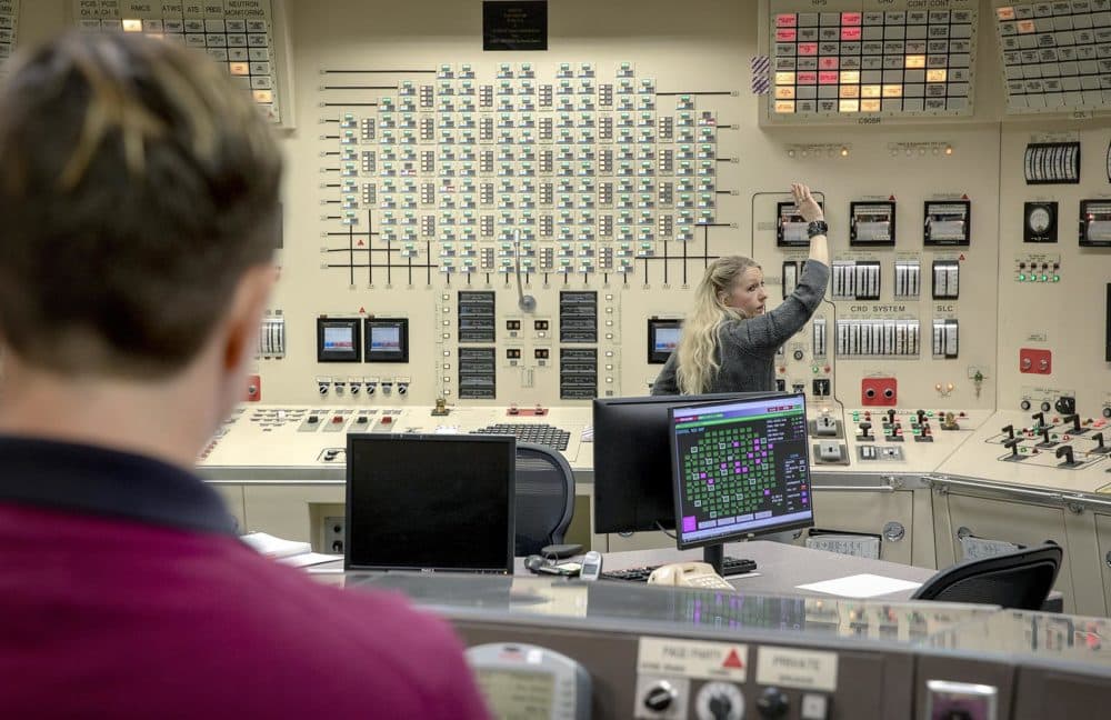 Trainers Christina Renaud, foreground, and Karla Kristiansen run through a drill at Pilgrim's control room simulator. (Robin Lubbock/WBUR)