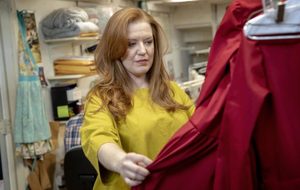 Jennifer Johnson Cano looks through Handmaids' costumes on a visit to Costume Works. (Robin Lubbock/WBUR)