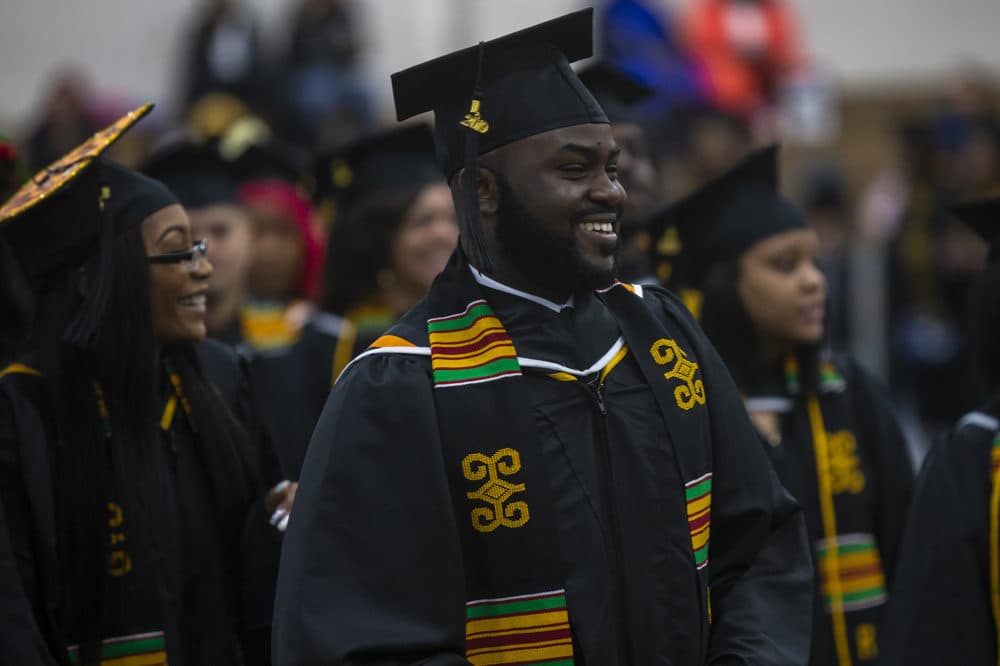 Smiling Roxbury Community College graduates during commencement. (Jesse Costa/WBUR)