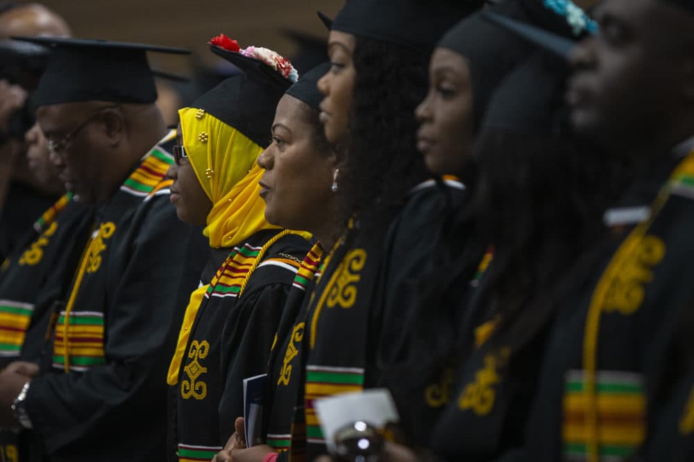 Roxbury Community College graduates listen to the commencement address given by Mayra Leith, class of 1985. (Jesse Costa/WBUR)