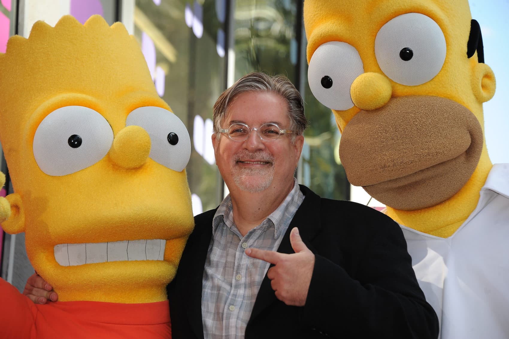 Cartoonist Matt Groening, creator of &quot;The Simpsons,&quot; poses with his characters Bart (left) and Homer Simpson. &quot;The Simpsons&quot; celebrates its 30th anniversary this year. (Robyn Beck/AFP/Getty Images)