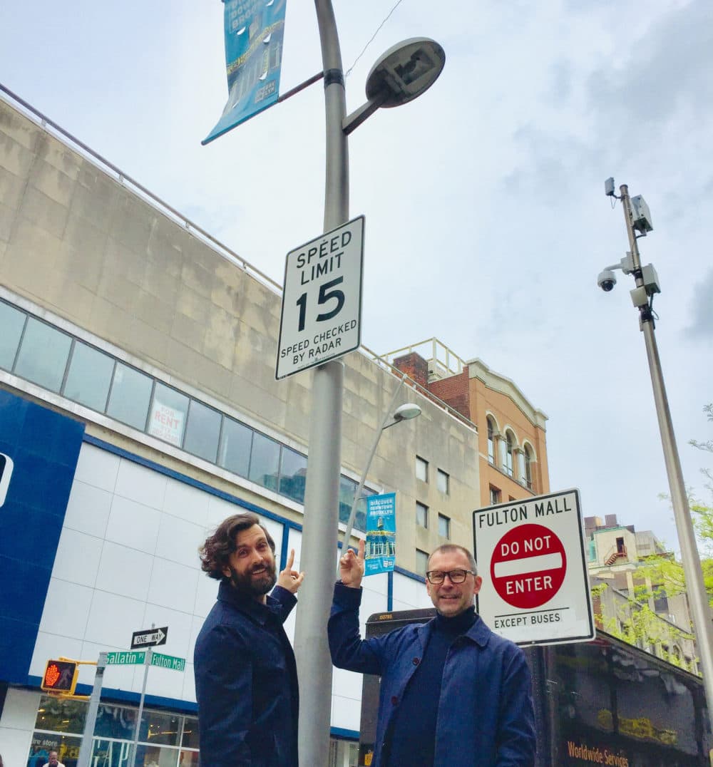 SONYC research scientist Mark Cartwright (left) and postdoctoral researcher Graham Dove point to an audio sensor in Brooklyn. (Karyn Miller-Medzon/Here & Now)