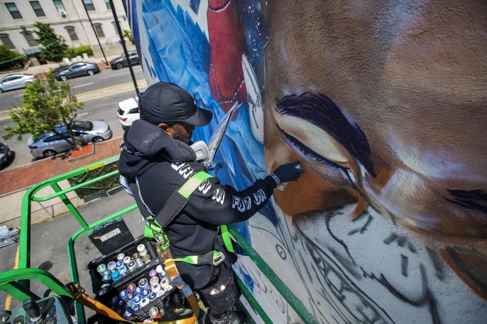 Artist Rob "Problak" Gibbs paints "Breathe Life 3" on the side of a three story building. (Jesse Costa/WBUR)