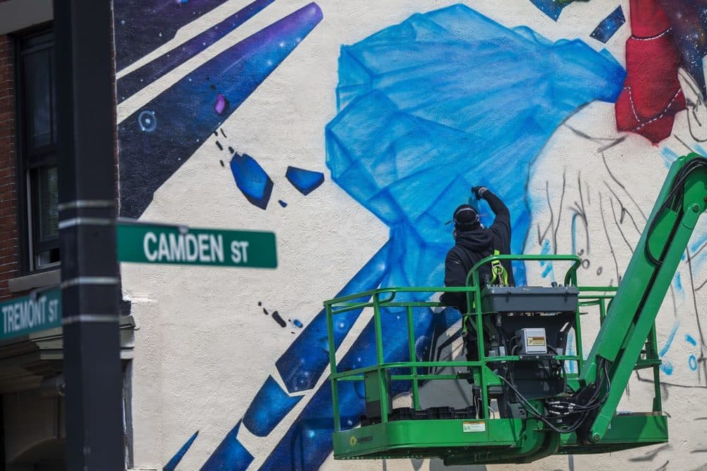 Artist Rob "Problak" Gibbs works on his latest mural, "Breathe Life," on the side of 808 Tremont St. in Roxbury. (Jesse Costa/WBUR)