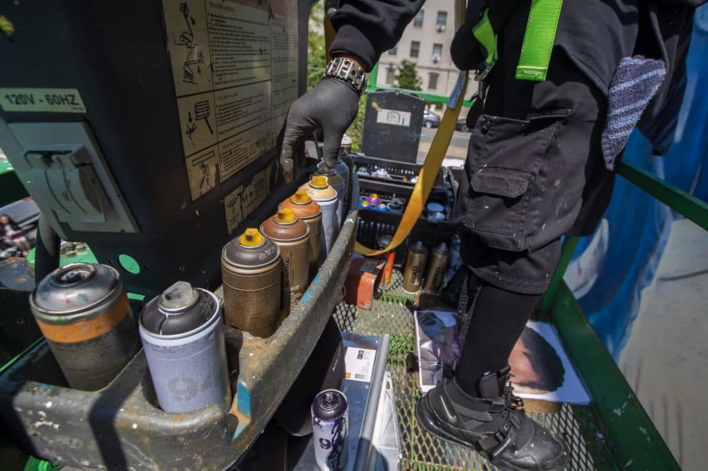 Gibbs reaches for a new can of spray paint. (Jesse Costa/WBUR)
