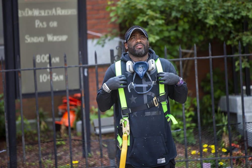 Artist Rob "Problak" Gibbs examines the work thus far on his latest mural. (Jesse Costa/WBUR)