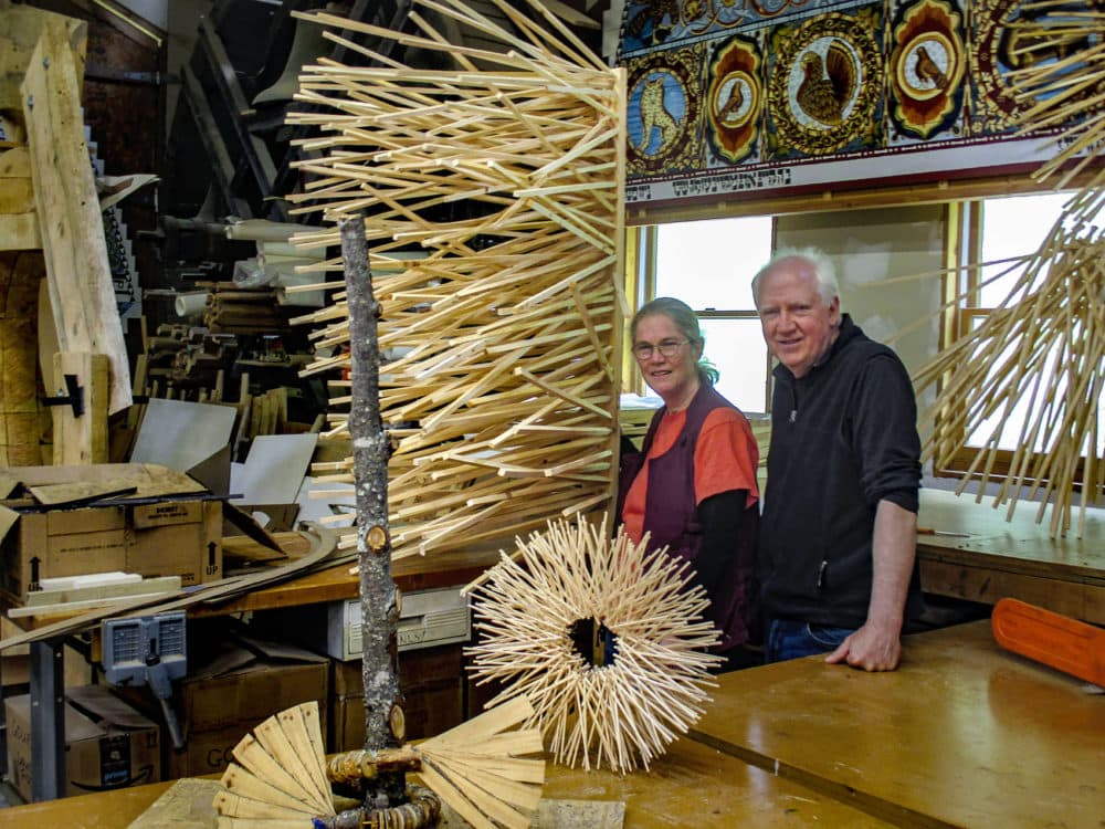 Laura and Rick Brown at Handshouse Studio, next to a small scale model of "Singing Tree," one of the planned sculptures for the Chesterwood exhibit. In the lower left is a model of "Mother Tree." (Penny Schwartz for WBUR)