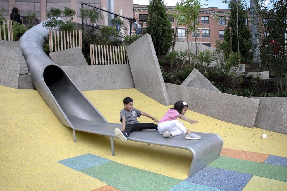 Krishen and Tara emerge from a ride down the tube slide at Martin's Park. (Robin Lubbock/WBUR)
