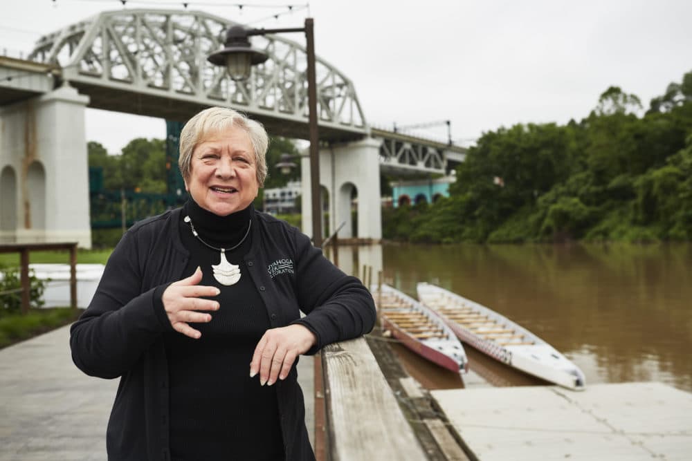 Jane Goodman, executive director of Cuyahoga River Restoration, stands by the river in Cleveland. This week marks 50 years since the 13th and last recorded river fire in 1969. (Paul Sobota for Here & Now)