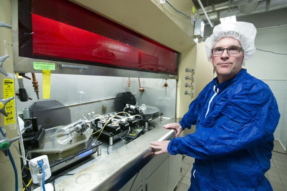 Dr. Daniel Conklin stands next to a device that can smoke cigarettes or vape from e-cigarettes and analyze the results in his lab at the University of Louisville. (Chris Bentley/Here & Now)