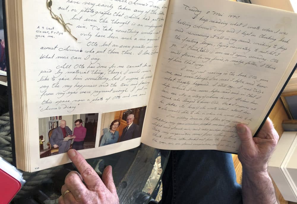 Ryan Cooper is pointing to a photo of him with Otto Frank while holding Anne's original diary. (Philip Marcelo/AP)