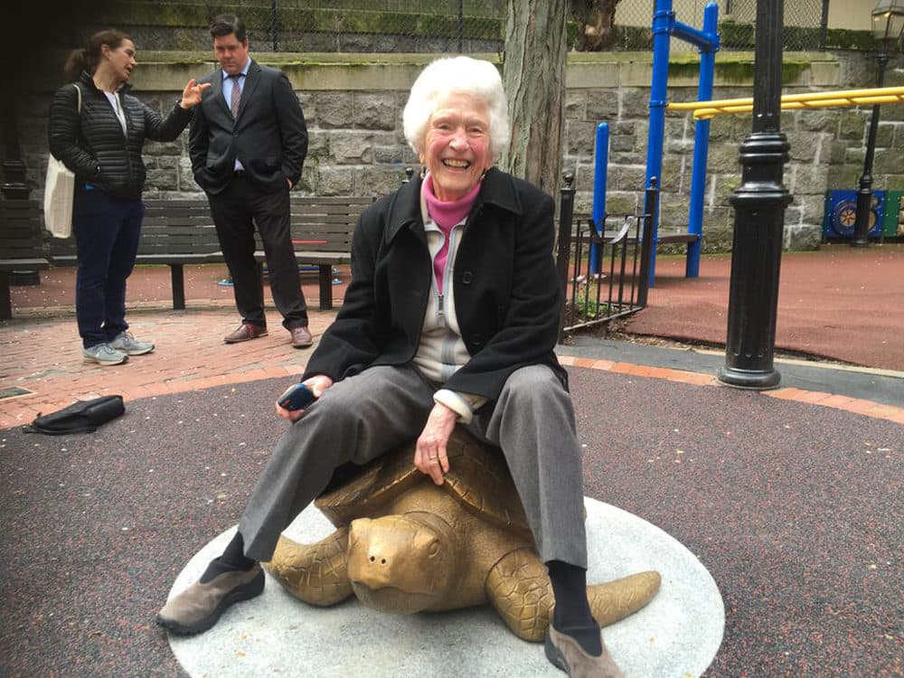 Nancy Schön sits atop her sculpture "Myrtle the Turtle" last month. (Courtesy New England Aquarium)