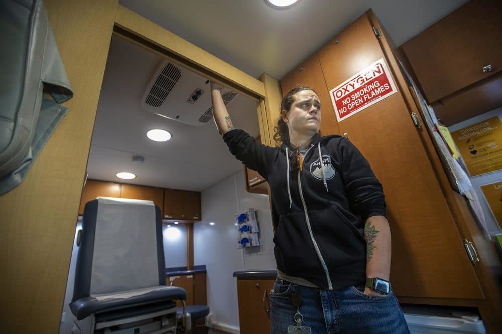 Sarah Mackin stands at the door as the Care Zone van crosses downtown Boston. (Jesse Costa / WBUR)