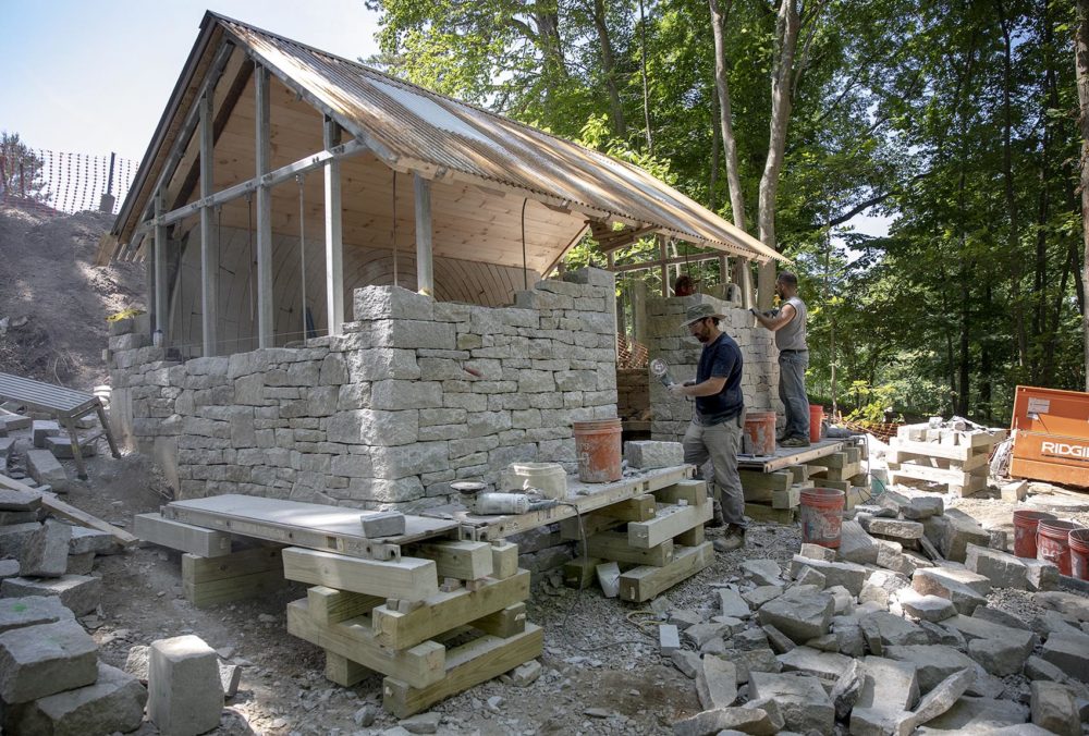 Dry stone wallers from the U.K. work on "Watershed" at deCordova. (Robin Lubbock/WBUR)