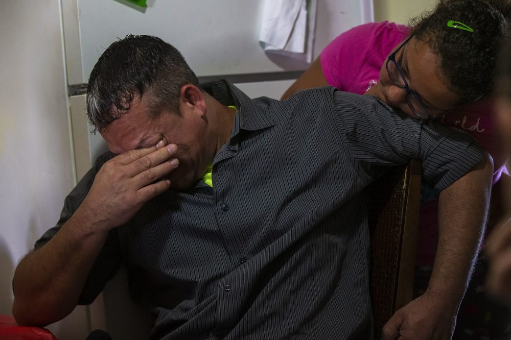 An emotional Gilberto Pereira Brito is consoled by his 10-year-old daughter, Tatyana, as he describes his experience being in detention for over three months after being arrested by ICE. (Jesse Costa/WBUR)