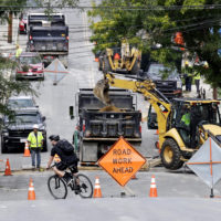 A bicyclist takes a turn at a road block as utility contractors dig up the road above natural gas lines along Brookfield Street in Lawrence, Mass. in September last year. (Charles Krupa/AP)