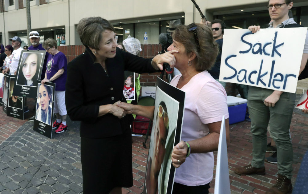 Healey, left, wipes a tear from the face of Wendy Werbiskis, of Easthampton, Mass., one of the demonstrators gathered outside the courthouse in Boston. (Charles Krupa/AP)