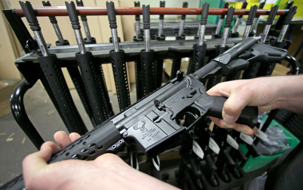 In this April 10, 2013 file photo, craftsman Veetek Witkowski holds a newly assembled AR-15 rifle at the Stag Arms company in New Britain, Conn. (Charles Krupa/AP)