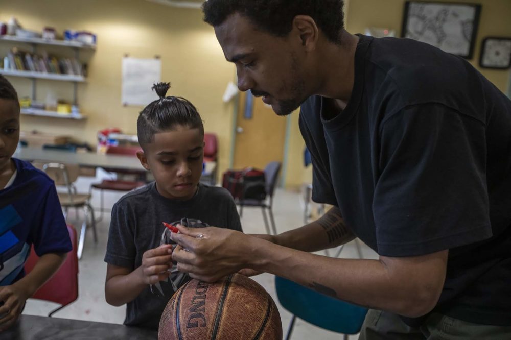 Artist Shaka Dendy prepares markers for a group of boys at the Yawkey Boys and Girls Club in Roxbury. (Jesse Costa/WBUR)