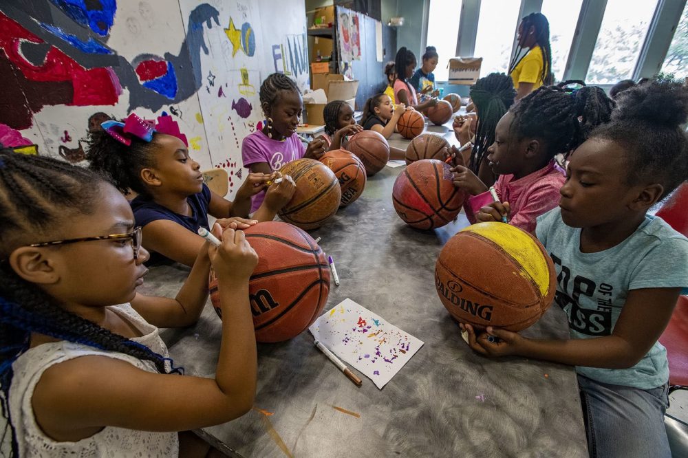 A group of 8-year-old girls decorate old basketballs. (Jesse Costa/WBUR)