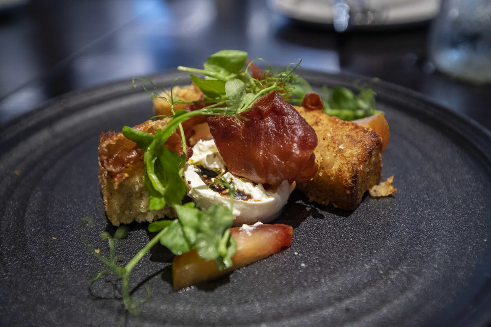 Burrata with pluots, grilled Plimoth cornbread, crispy prosciutto and pea shoots at Trillium Brewing Fort Point. (Jesse Costa/WBUR)