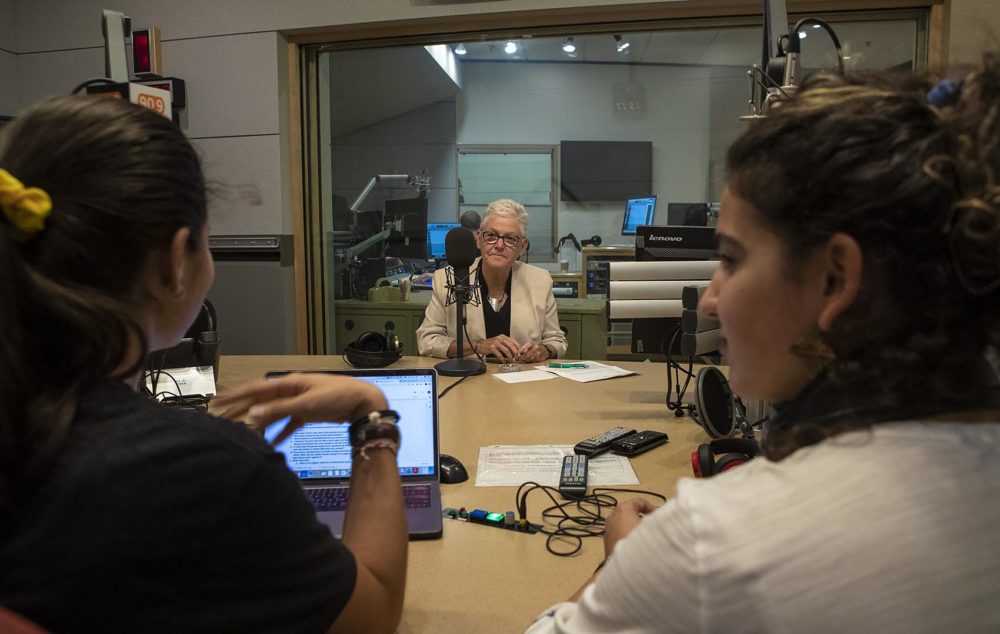 Audrey Lin, left, and Saya Ameli Hajebi speak with former head of the Environmental Protection Agency Gina McCarthy at the WBUR studios. (Jesse Costa/WBUR)