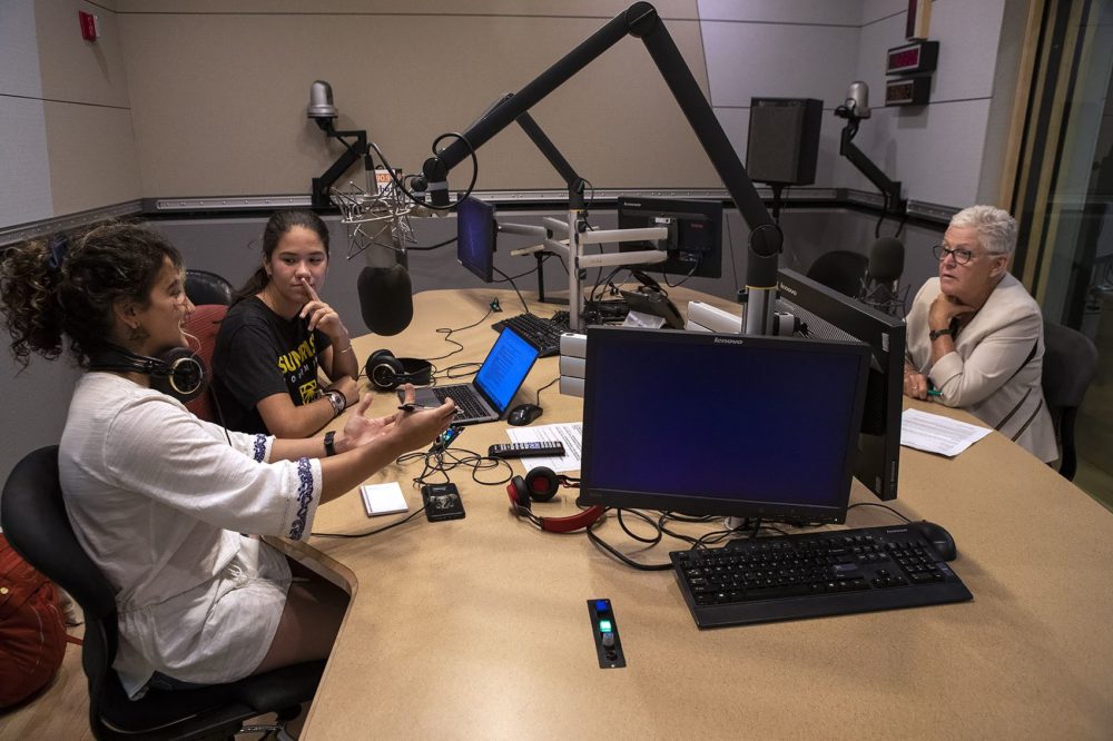 Saya Ameli Hajebi, left and Audrey Lin speak with former head of the Environmental Protection Agency Gina McCarthy at the WBUR studios. (Jesse Costa/WBUR)
