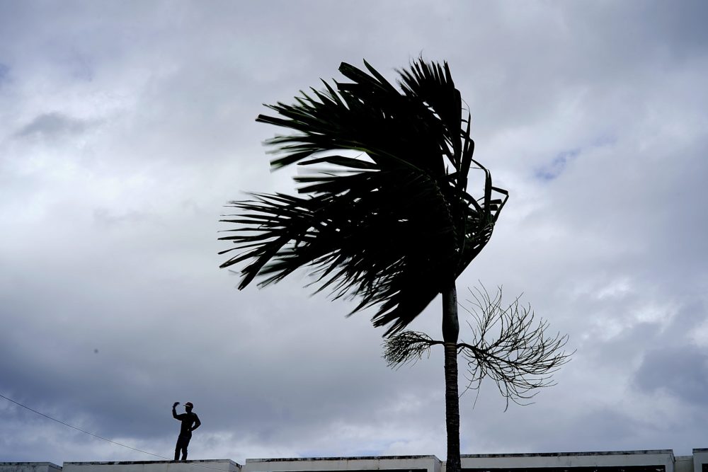 A man stands on a store's roof as he works to prepare it for the arrival of Hurricane Dorian on Sunday, Sept. 1, 2019. (Ramon Espinosa/AP)