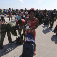 A Bahama's Army officer registers the people prior boarding a ferry to Nassau at the Port in Marsh Harbor, Abaco Island, Bahamas, Saturday, Sept. 7, 2019. The Bahamian health ministry said helicopters and boats are on the way to help people in affected areas, though officials warned of delays because of severe flooding and limited access. (Fernando Llano/AP)