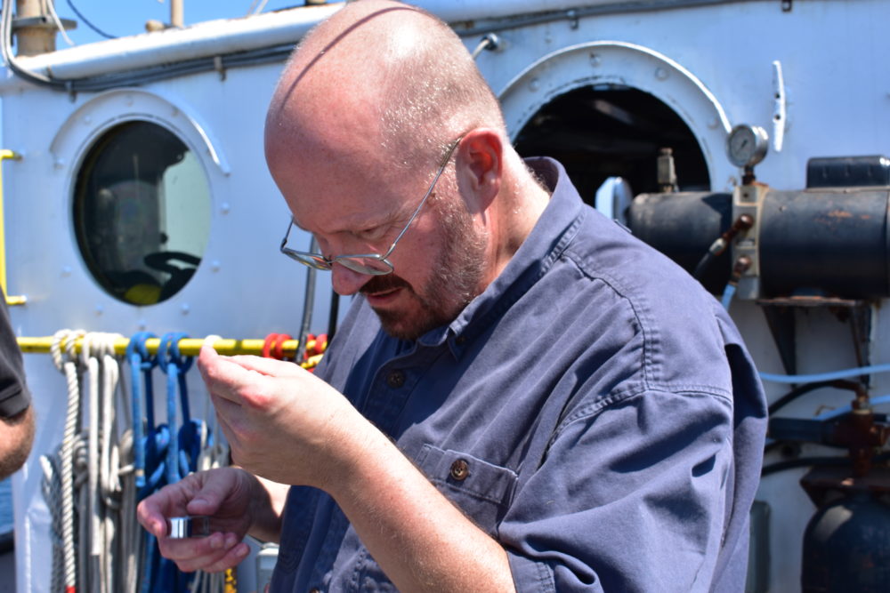 Hammergren takes a close look at sediment brought to the surface by the Aquarius Project. (Courtesy of Adler Planetarium)