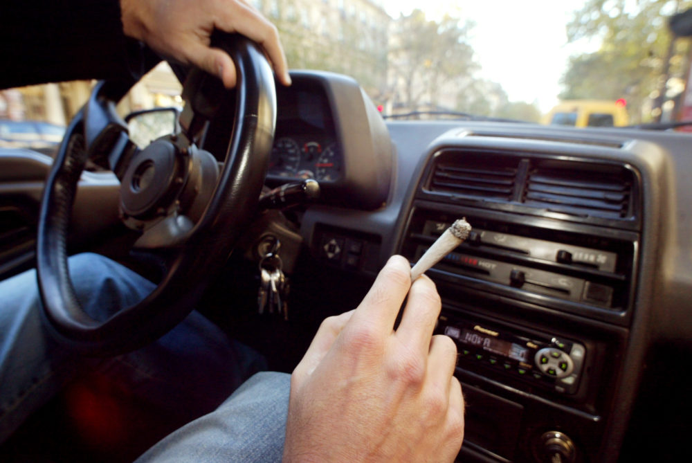 A person smokes a weed cigarette in their car. (Francois Guillot/Getty Images)
