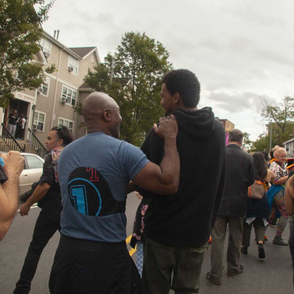 Nick Cave, left, shares a moment with Boston Center of the Art’s artist-in-residence Shaka Dendy as they pass through Dendy's childhood neighborhood. (OJ Slaughter for WBUR)