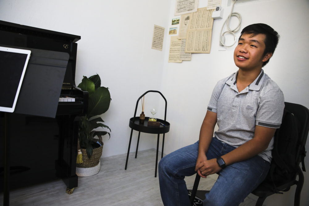 Eric Chan listens to Jean Huang perform during a "Concert for One" in Chinatown. (Erin Clark for WBUR)