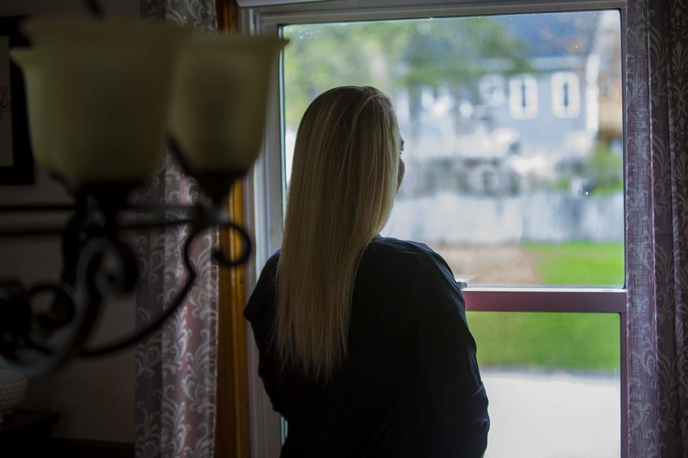 A woman whose last name is Smith, seen here in a family member's Massachusetts home, says she was sexually assaulted by a guard for Prisoner Transportation Services while being returned to the state for a probation violation. (Jesse Costa/WBUR)