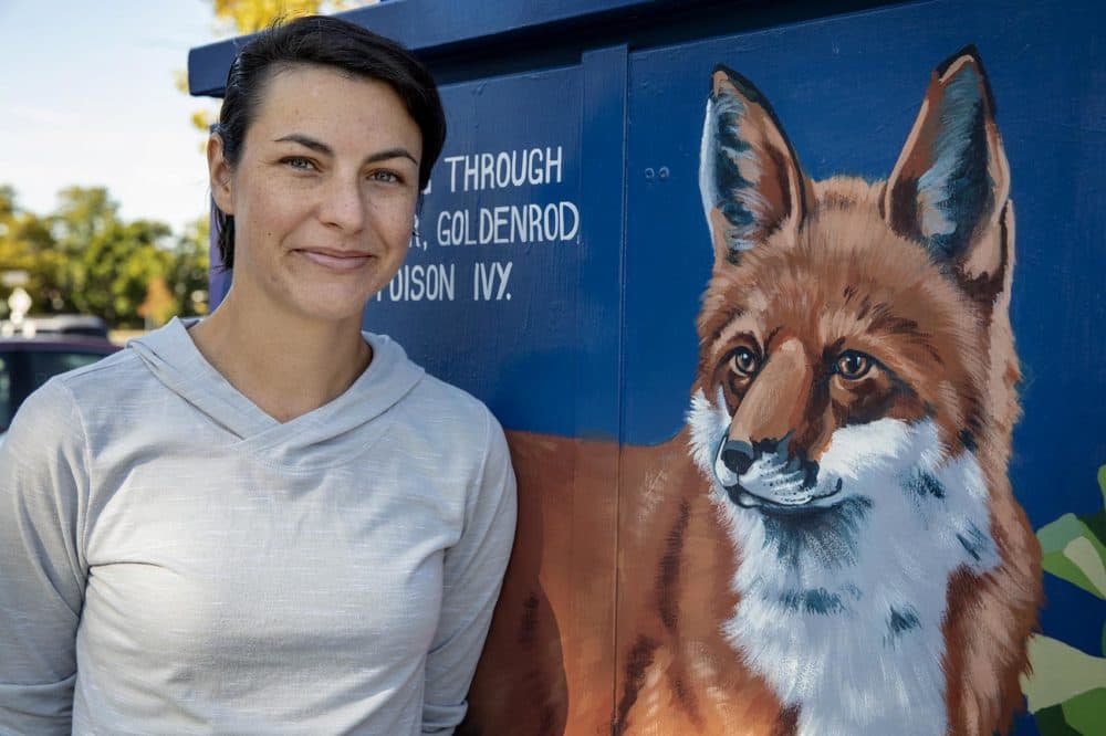 Artist Sophy Tuttle in front of her painting "Red Fox & Blue Wood Aster." (Robin Lubbock/WBUR)