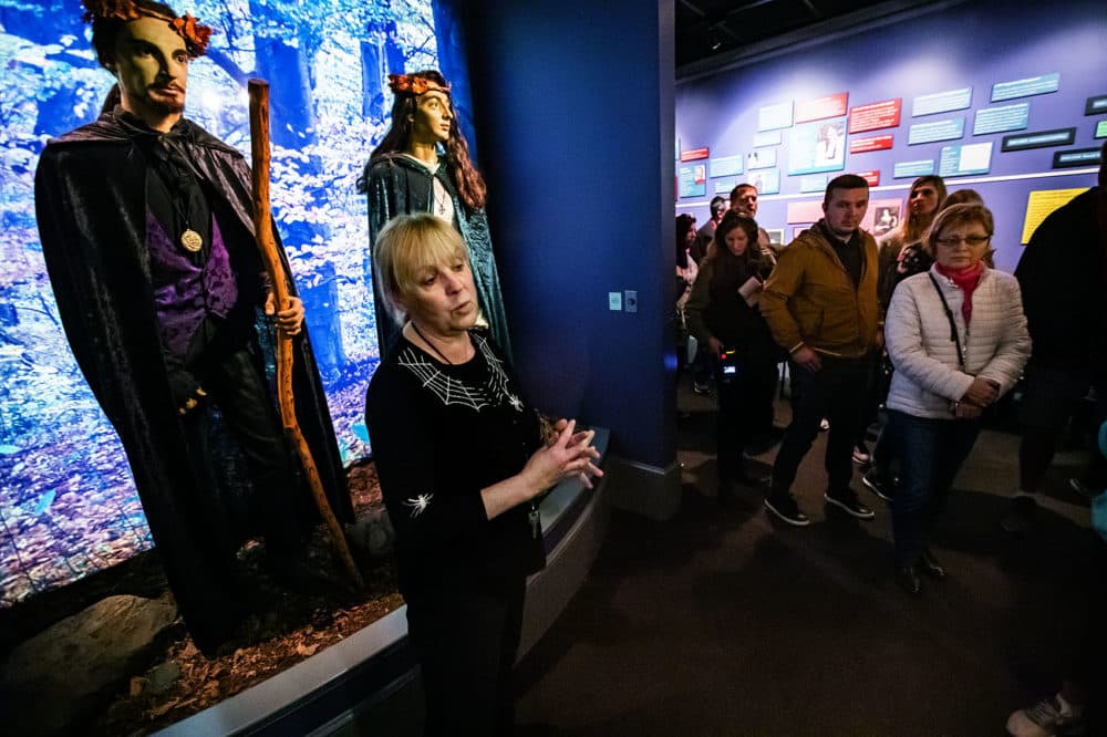 Jill Christiansen leads a tour at the Salem Witch Museum featuring depictions of witches throughout the centuries. (Jesse Costa/WBUR)