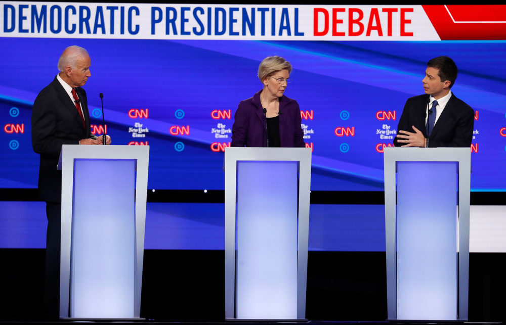 Former Vice President Joe Biden and Warren listen to South Bend Mayor Pete Buttigieg during a Democratic presidential primary debate on Oct. 15 in Westerville, Ohio. (John Minchillo/AP)
