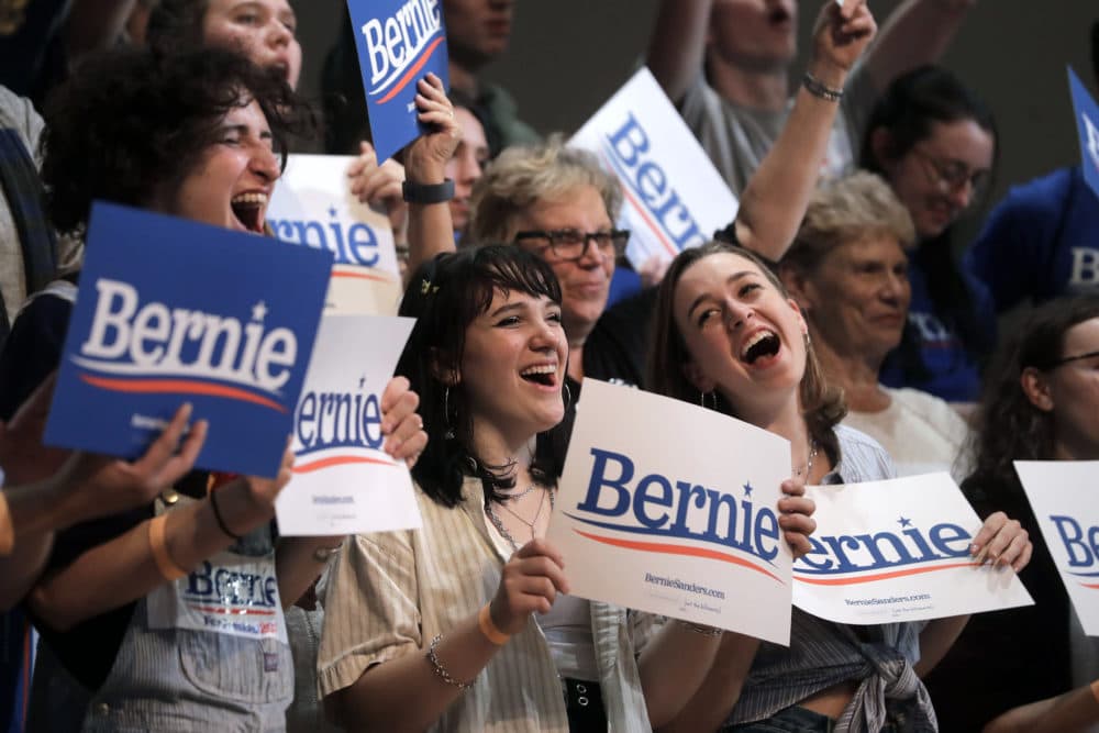 Sanders supporters wave placards at the campaign event Wednesday. (Steven Senne/AP)