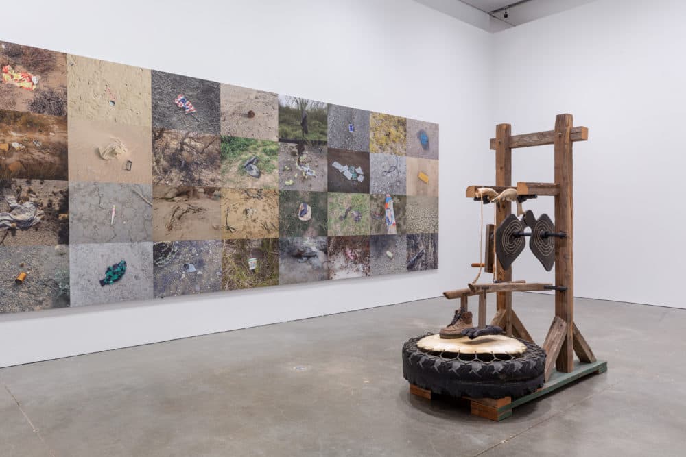 "Zapatello" by Guillermo Galindo sits next to a wall of photographs by Richard Misrach (Courtesy Mel Taing)