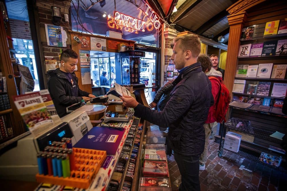 Dima Papusha, from Russia, purchases a magazine at the Out of Town News counter. (Jesse Costa/WBUR)