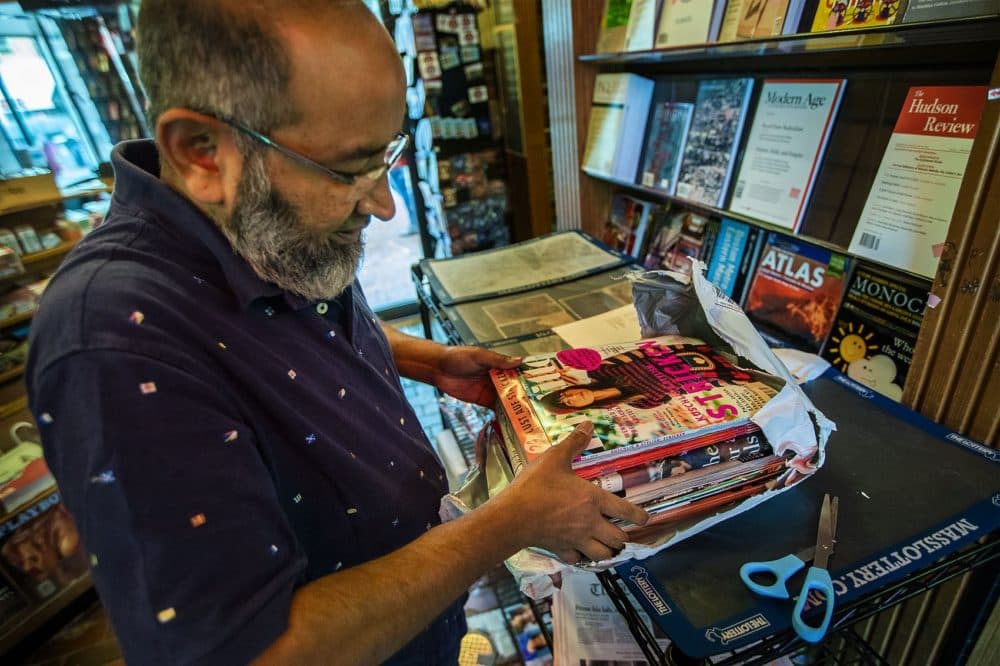 Mohammad Rahman unpacks some magazines to be restocked on the shelves. He worked at Out of Town News for 22 years. (Jesse Costa/WBUR)