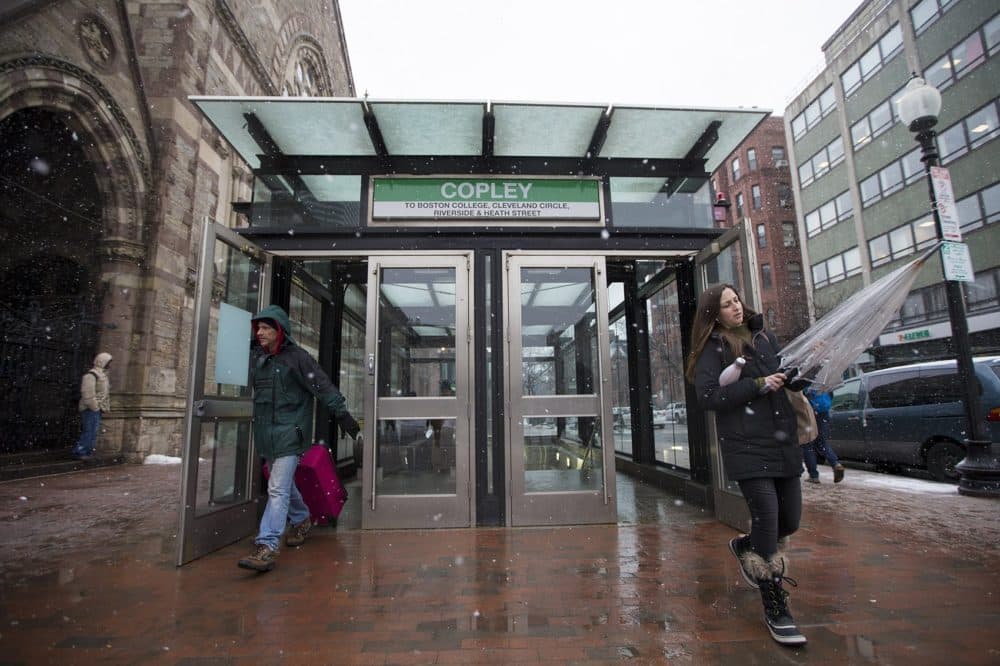 MBTA commuters leave Copley Station into the snow on Boylstion Street. (Jesse Costa/WBUR)