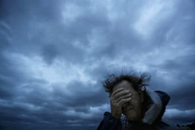 In this 2018 file photo, Russ Lewis covers his eyes from a gust of wind and a blast of sand as Hurricane Florence approaches Myrtle Beach, S.C. (David Goldman/AP)