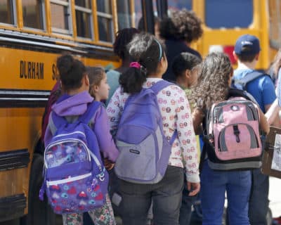 Students at Albany School of Humanities wait to board a bus after school on Monday, April 13, 2015, in Albany, N.Y. With standardized English tests set to begin Tuesday in New York schools, some parents are again planning to have their children sit out the exams. (Mike Groll/AP)